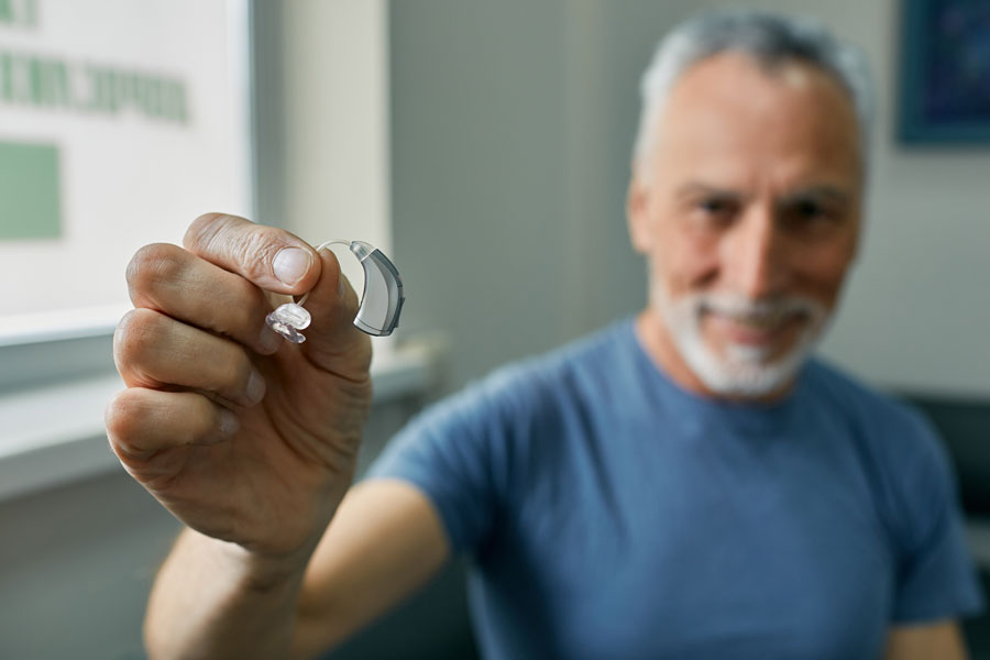 Hombre con un audífono en la mano