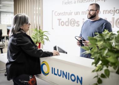 Un trabajador de ILUNION Contact Center BPO atiende a una mujer senior en recepción