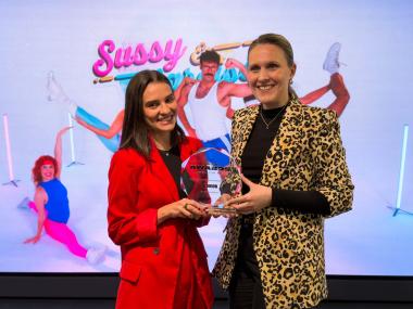 Andrea Durán sostiene el premio otorgado a ILUNION junto a una compañera de ILUNION Comunicación Social