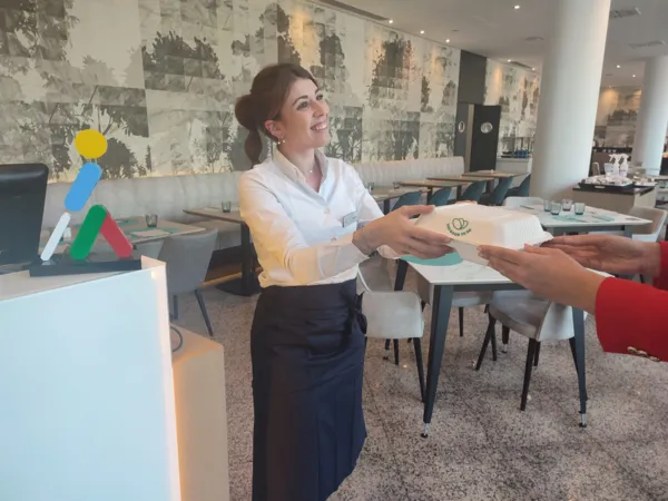 Imagen de una empleada de ILUNION Hotels entregando comida
