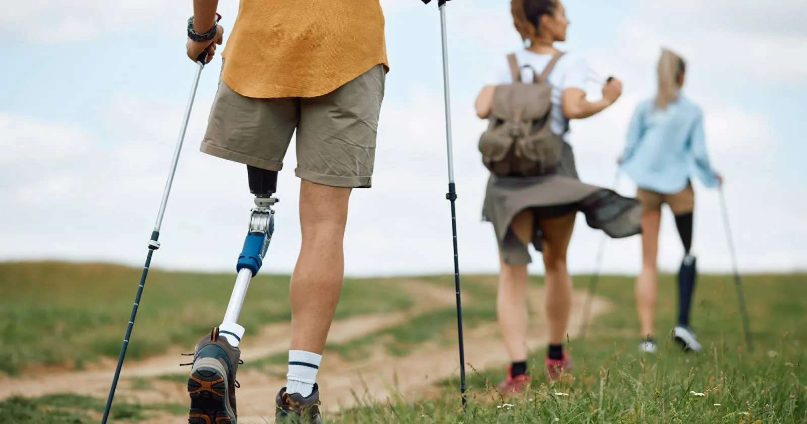 Una familia, dos de sus componentes con prótesis en una de las piernas, caminan por una zona de naturaleza