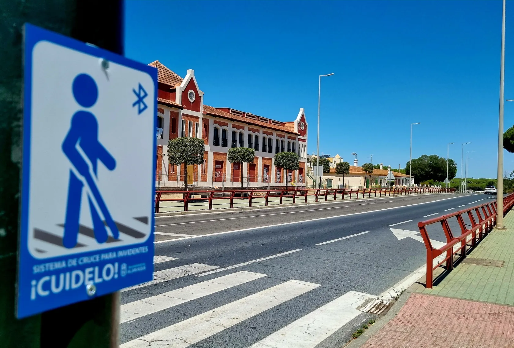 Fotografía de un paso de peatones de Aljaraque con la señal indicadora del semáforo interactivo a demanda