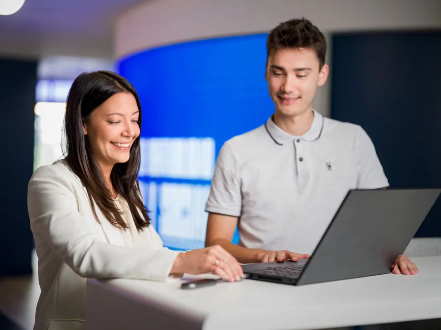 dos jóvenes mirando un ordenador en un entorno de trabajo