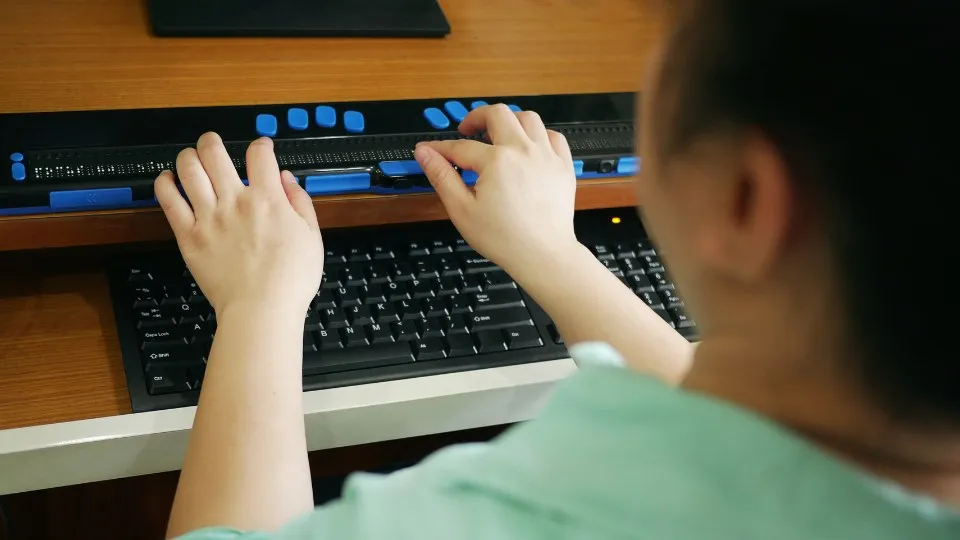 Una mujer utilizando un teclado braille