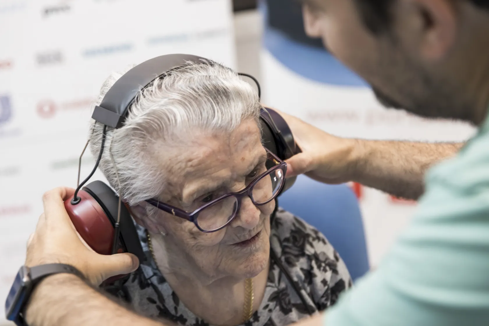 Un audiólogo coloca unos auriculares a una mujer mayor de la residencia ILUNION VidaSénior en Sonseca