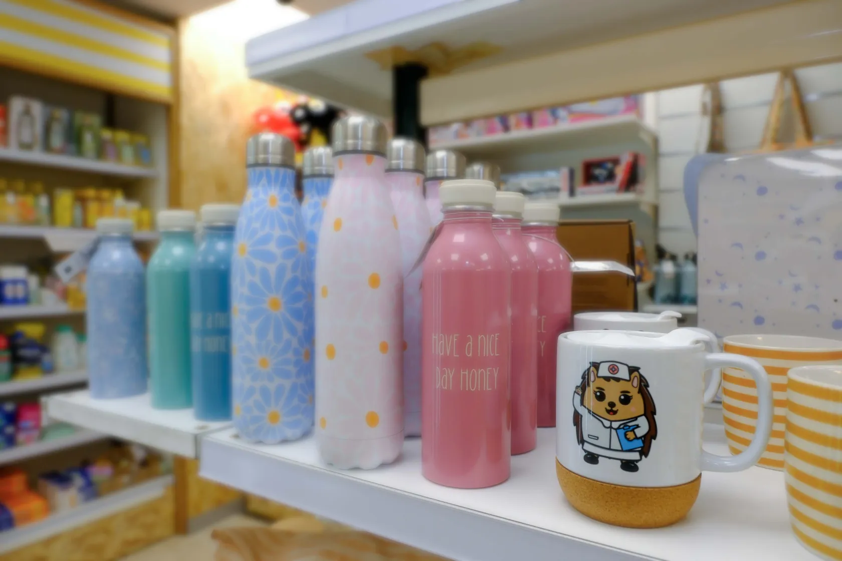 Detalle de termos que se venden en ILUNION TuTienda, junto con una taza en el que hay dibujado un erizo doctor sonriente