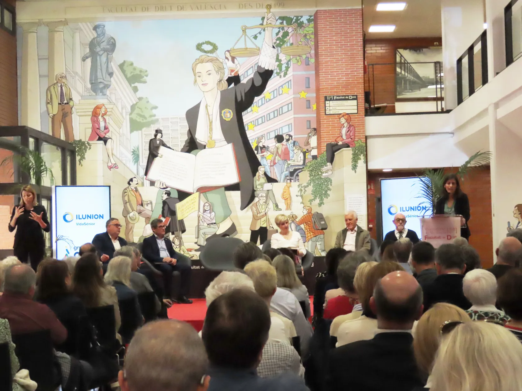 El público mira y escucha a varios ponentes, al fondo, durante la presentación de LogenvidadLab