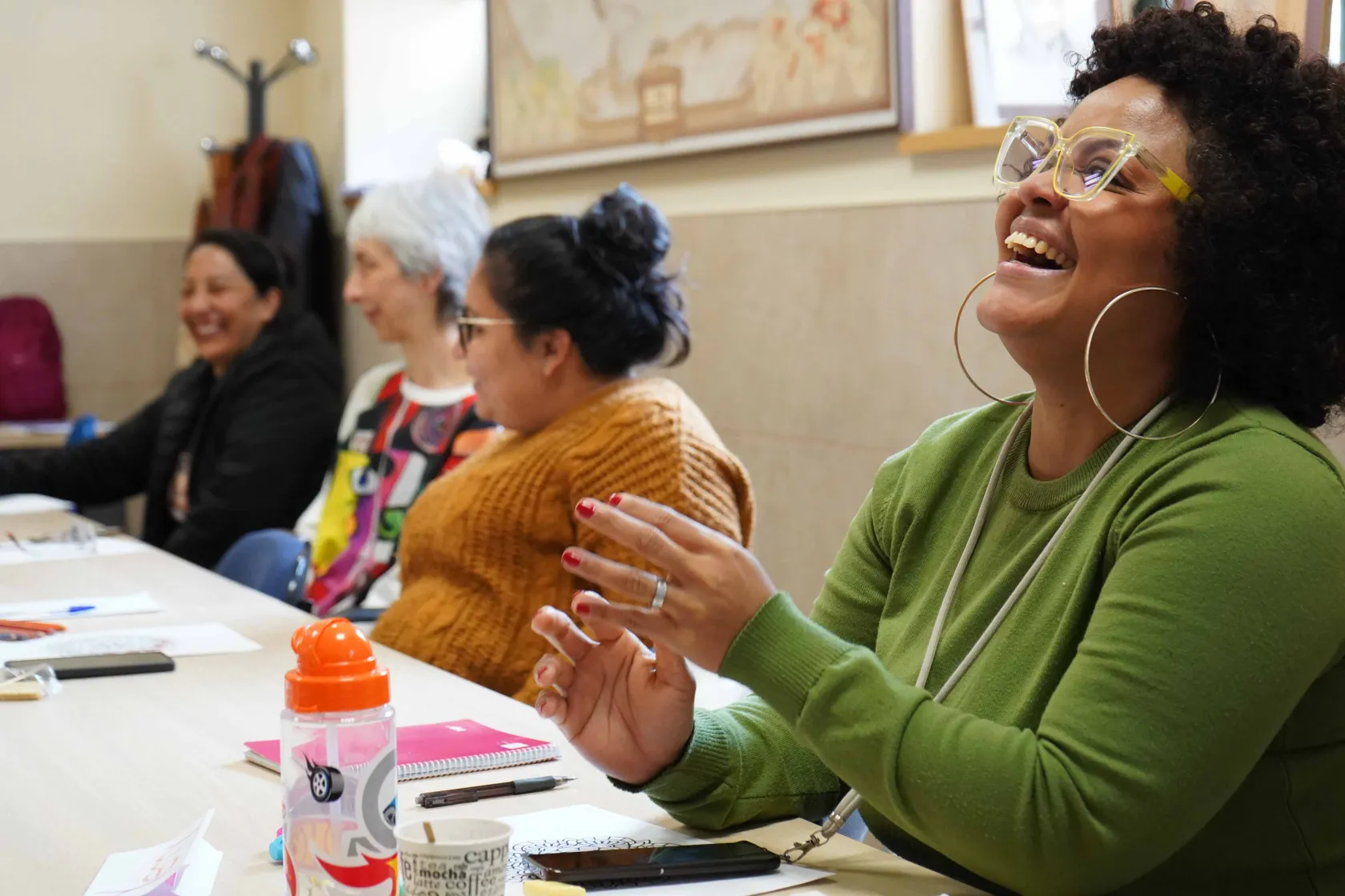 Varias mujeres sonrientes en una aula de formación. Copyright de la fotografía Paola Gómez
