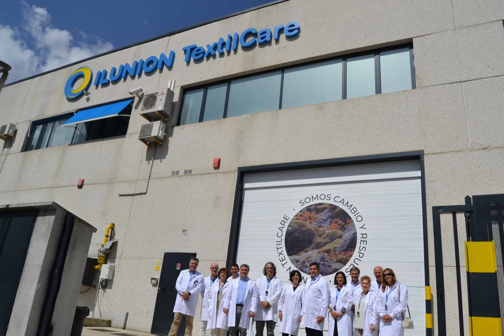 Fotografía de la comitiva parlamentaria navarra en la puerta de la planta de ILUNION TextilCare en Beriain