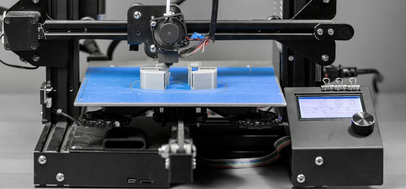 Se muestra una impresora 3D imprimiendo una pieza