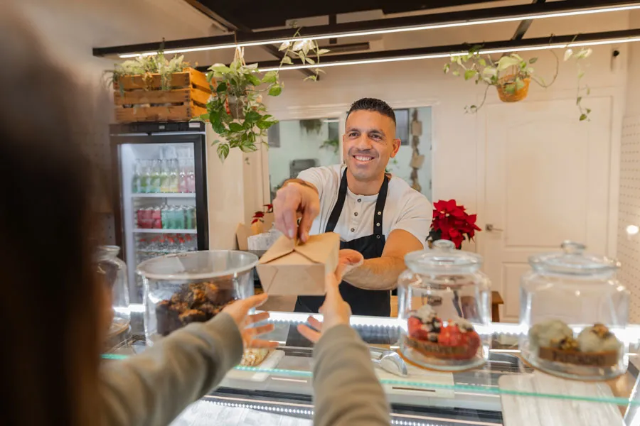 Dueño de un comercio local sirviendo a un cliente