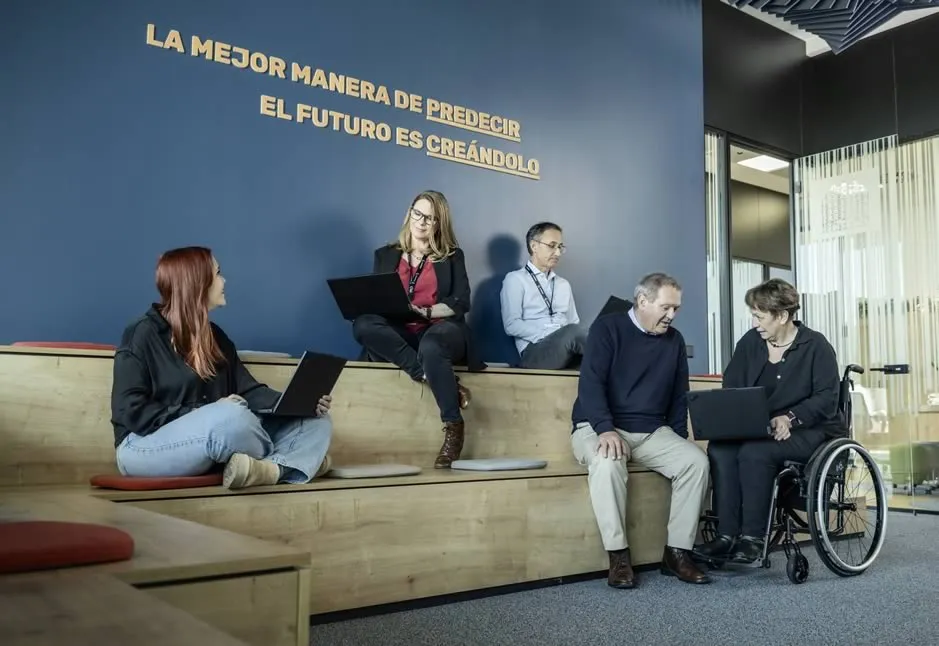 Grupo de Personas de ILUNION reunidos en una sala abierta con sofá