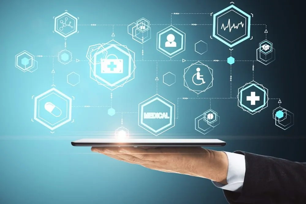 Mano sosteniendo una tablet con iconos médicos digitales flotando sobre fondo azul