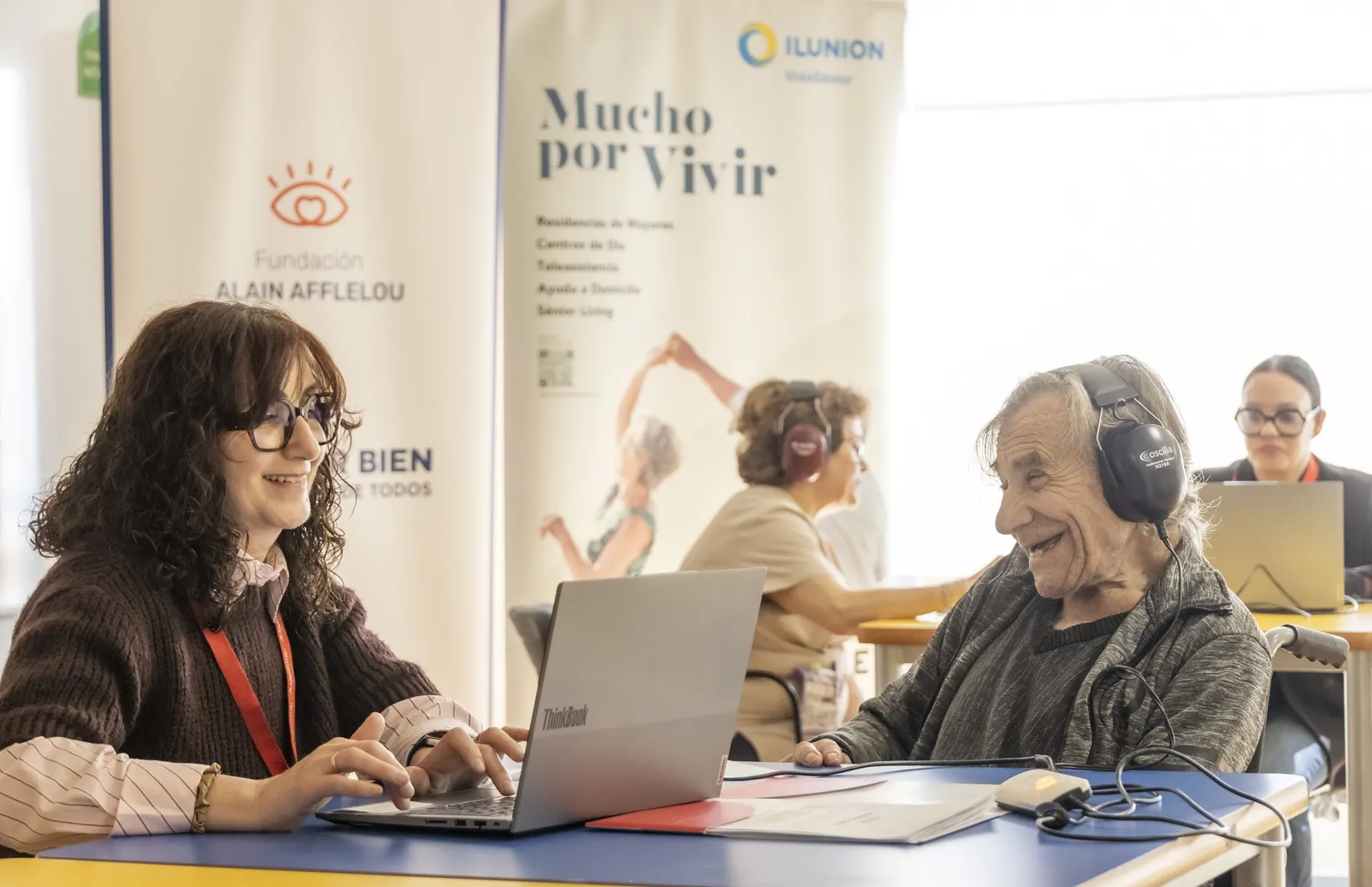 Una mujer mayor sonríe divertida mientras le realizan una audiometría