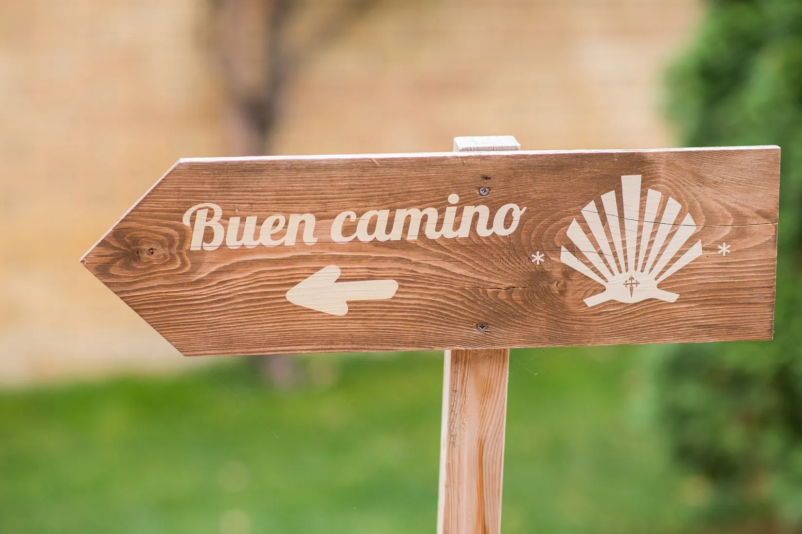Un letrero labrado en madera desea buen camino a los peregrinos del Camino de Santiago.
