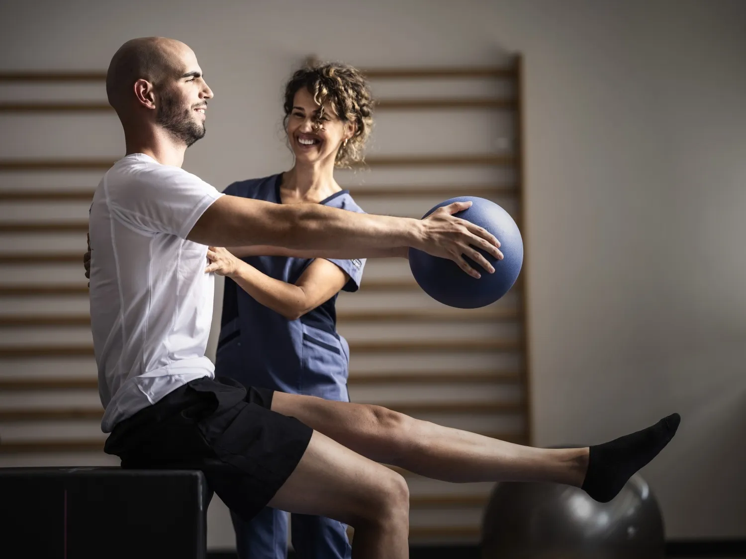 Un hombre realiza ejercicios físicos de pilates con una fisioterapeuta de ILUNION