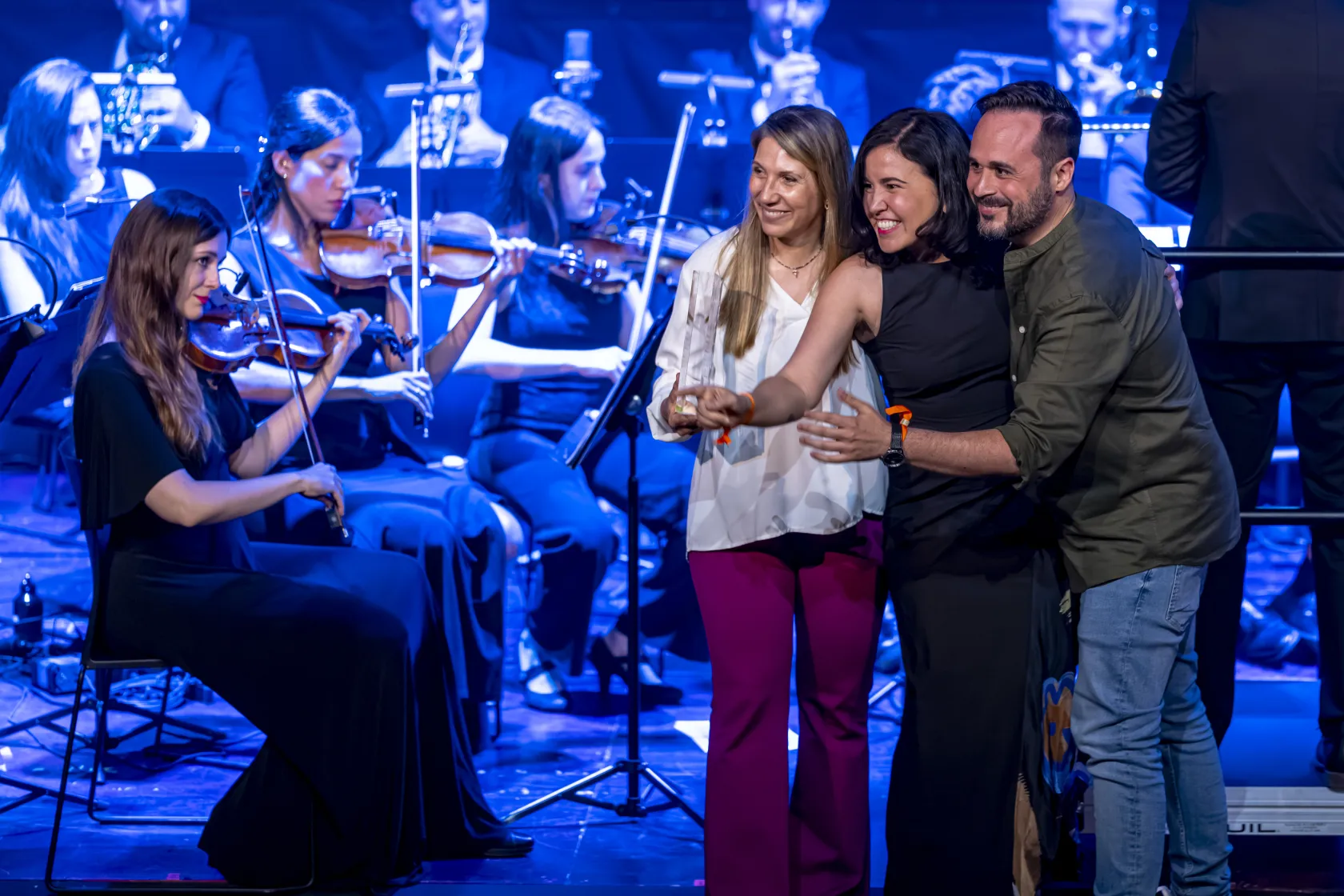 La directora de ILUNION Comunicación Social, Lucía Mateo, junto con dos miembros de su equipo, recogen el Premio DIRCOM por la campaña 'El efecto Mari Rosa'