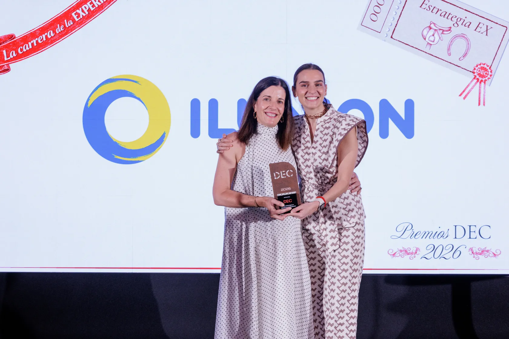 De izquierda a derecha, Esther Díaz y Andrea Durán, posan sosteniendo juntas el Premio DEC concedido a ILUNION