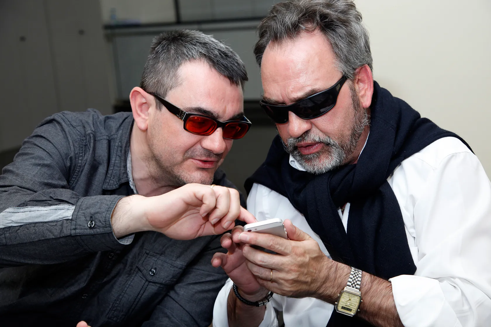 Dos hombres ciegos utilizando un teléfono móvil