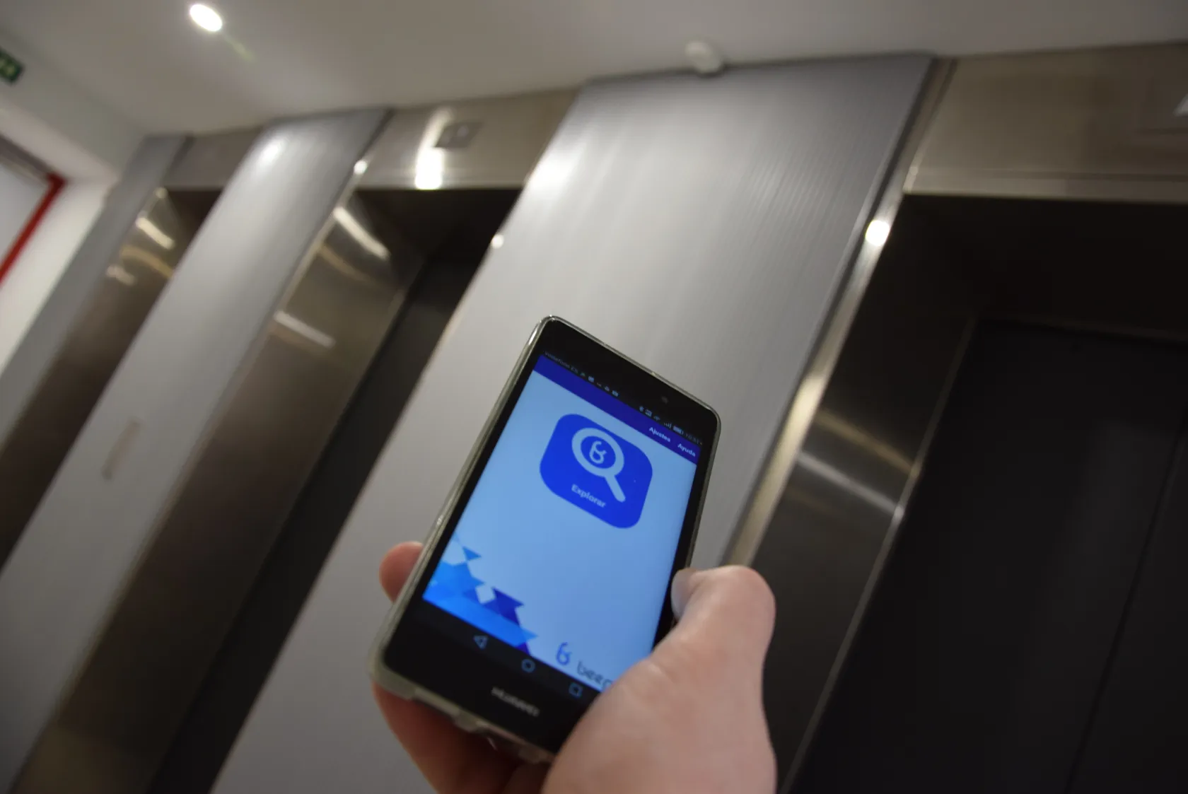 Aplicación móvil beepcon frente a una de las balizas inteligentes de guidado