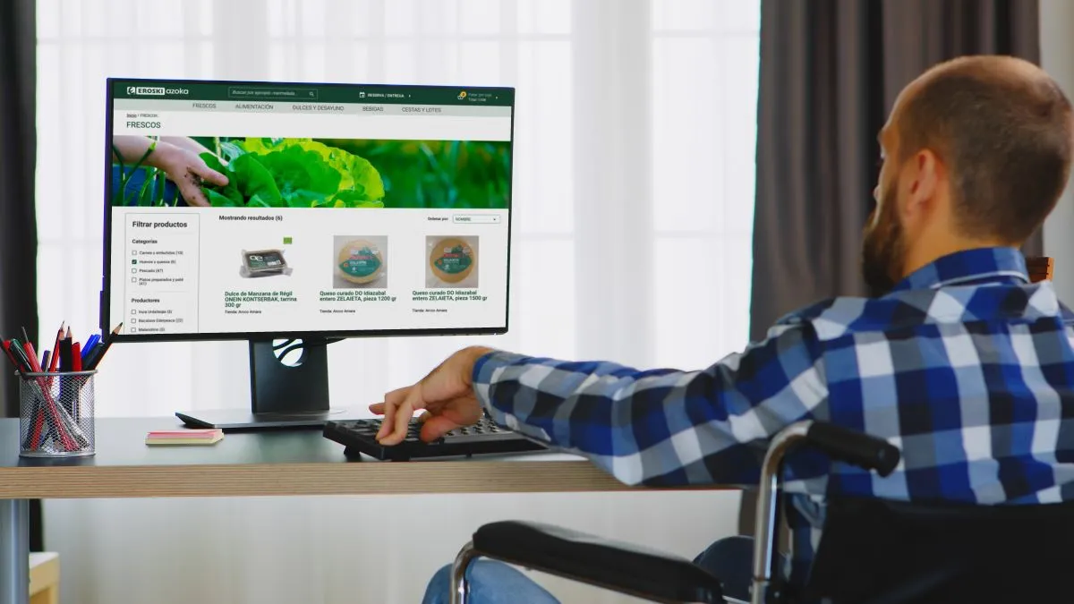 Un hombre usuario de ruedas navega por la nueva web accesible de Eroski y certificada por ILUNION Accesibilidad