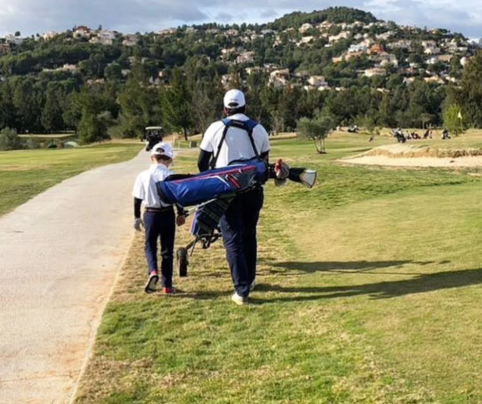 Pareja formada por padre e hijo juegan al golf.