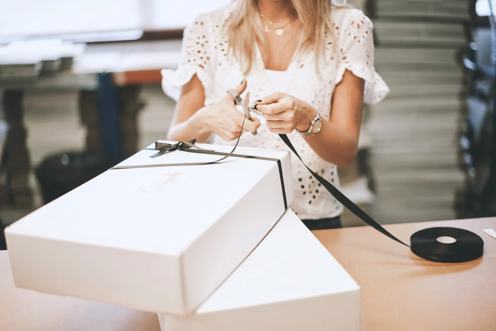 Detalle de una caja de Enriqueta que está siendo envuelta por una mujer 