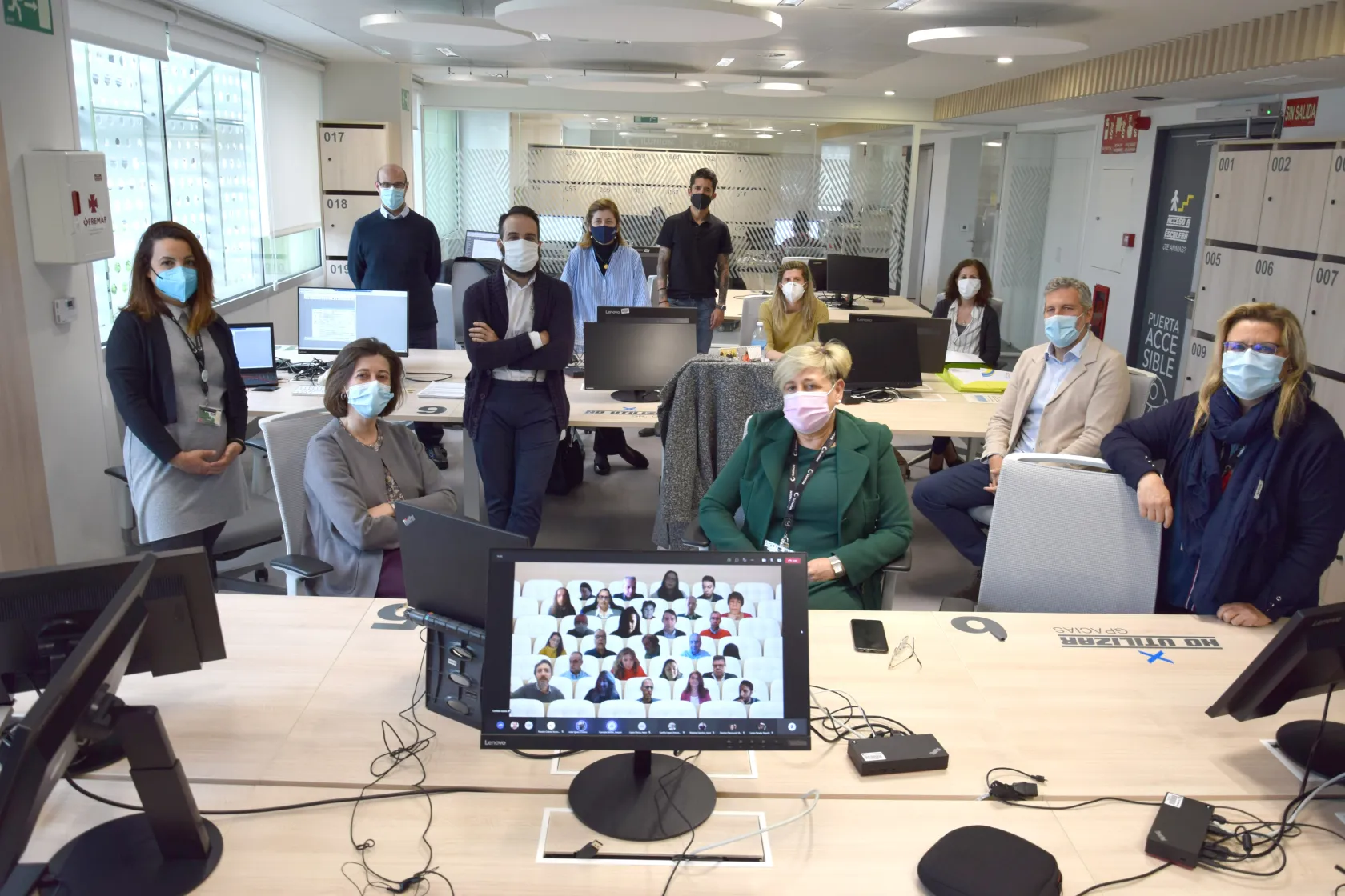 Foto de familia de los trabajadores de la Correduría. Además hay una pantalla donde aparecen las caras de los trabajadores de la compañía que están teletrabajando