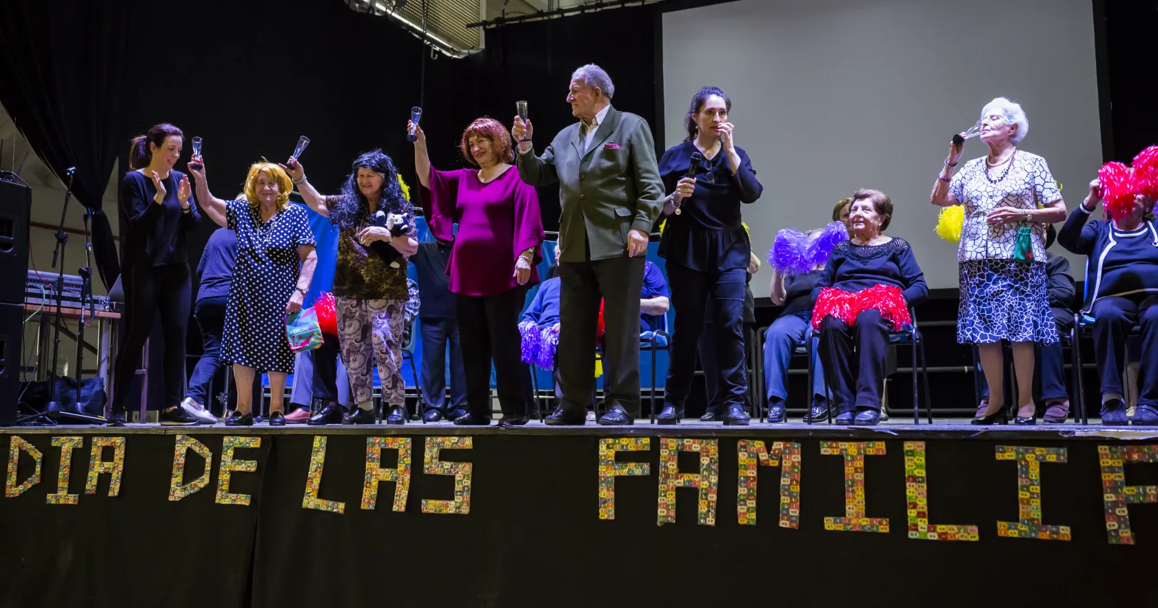 En la fotografía aparecen mayores en el escenario durante una actuación
