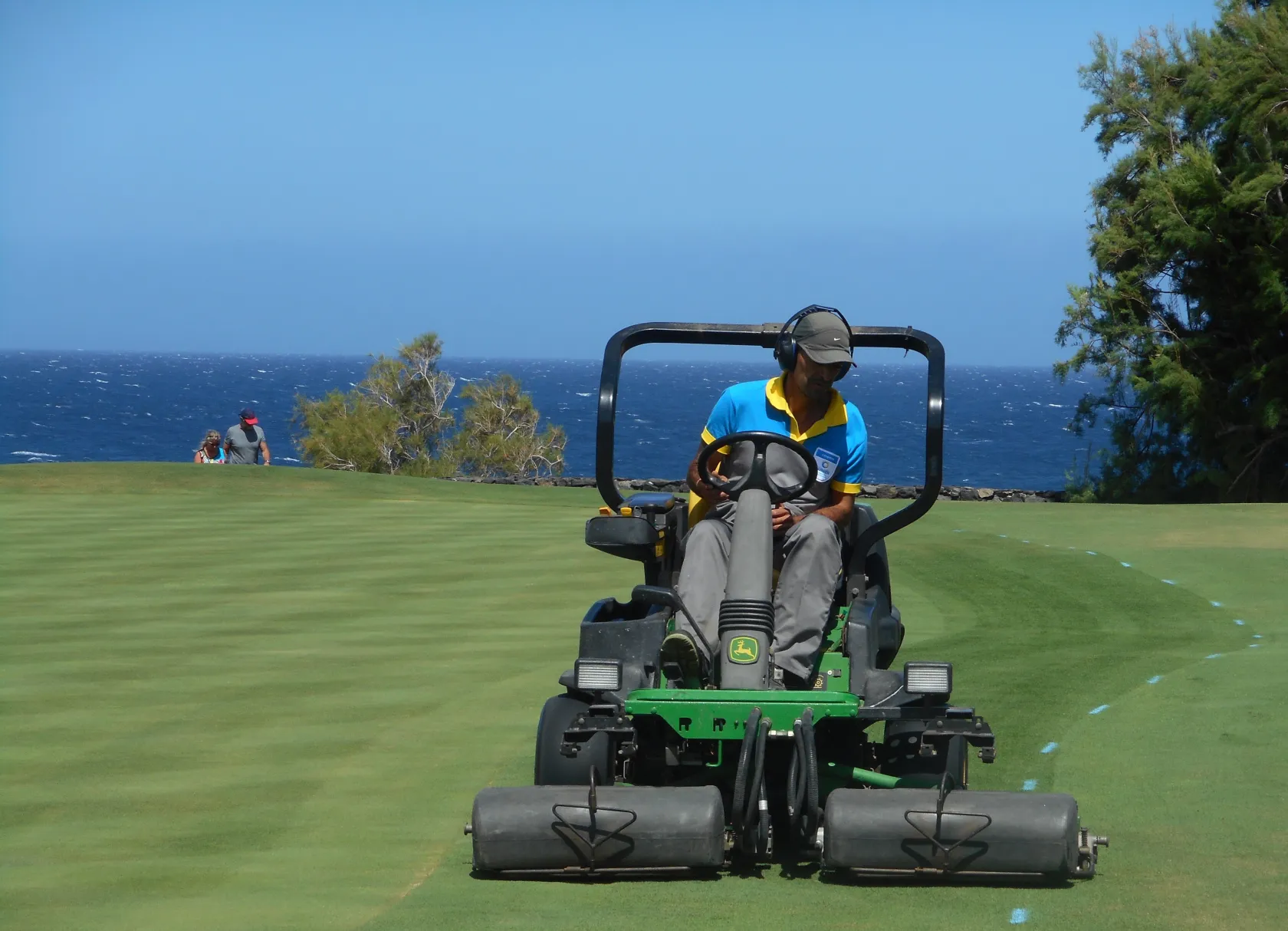 Trabajador de ILUNION Limpieza y Medio Ambiente subido a un cortador de cesped durante el cuidado de las instalaciones del campo de golf 