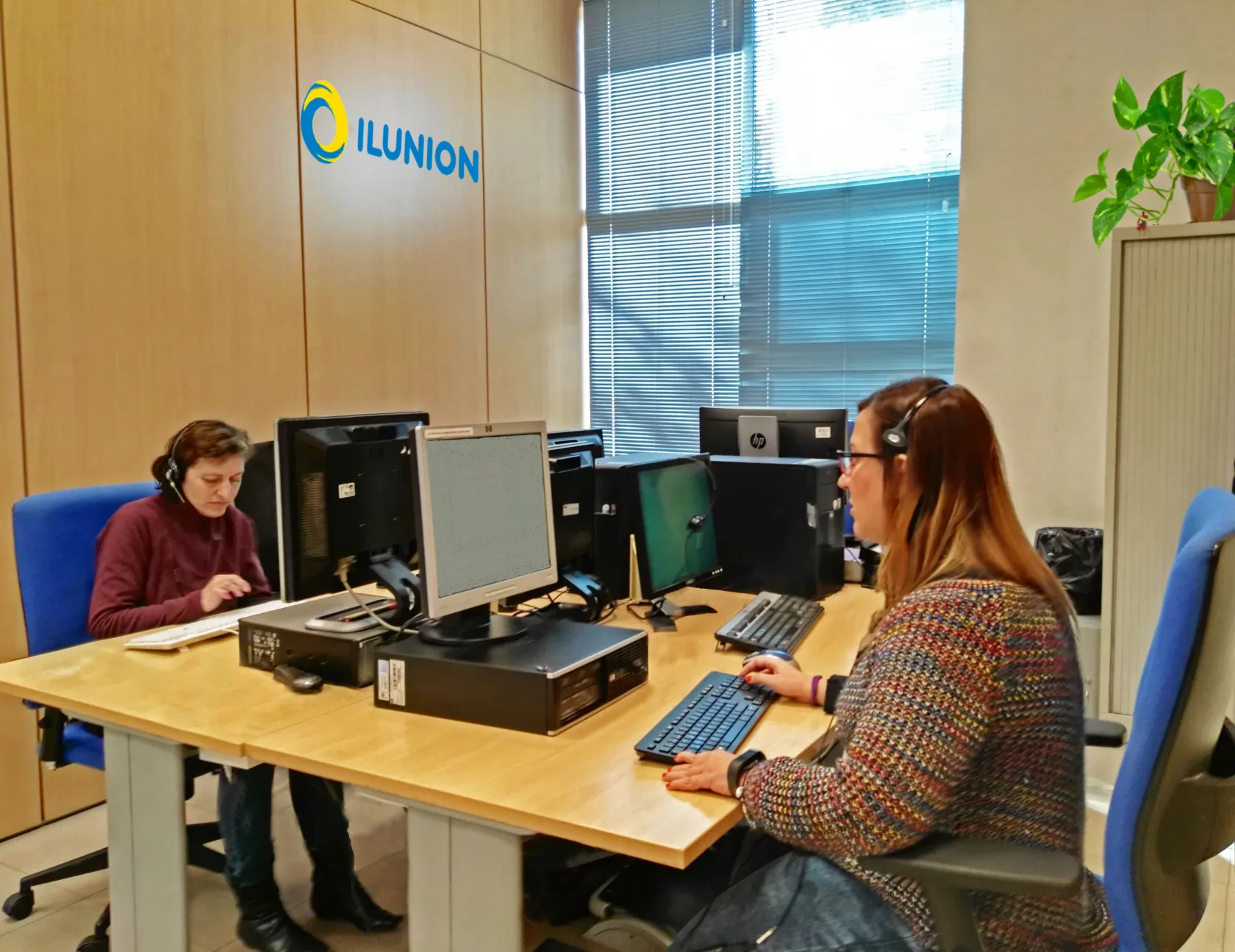 Dos trabajadores de ILUNION Contact Center BPO gestionando el servicio del Centro de Intermediación Telefónica 