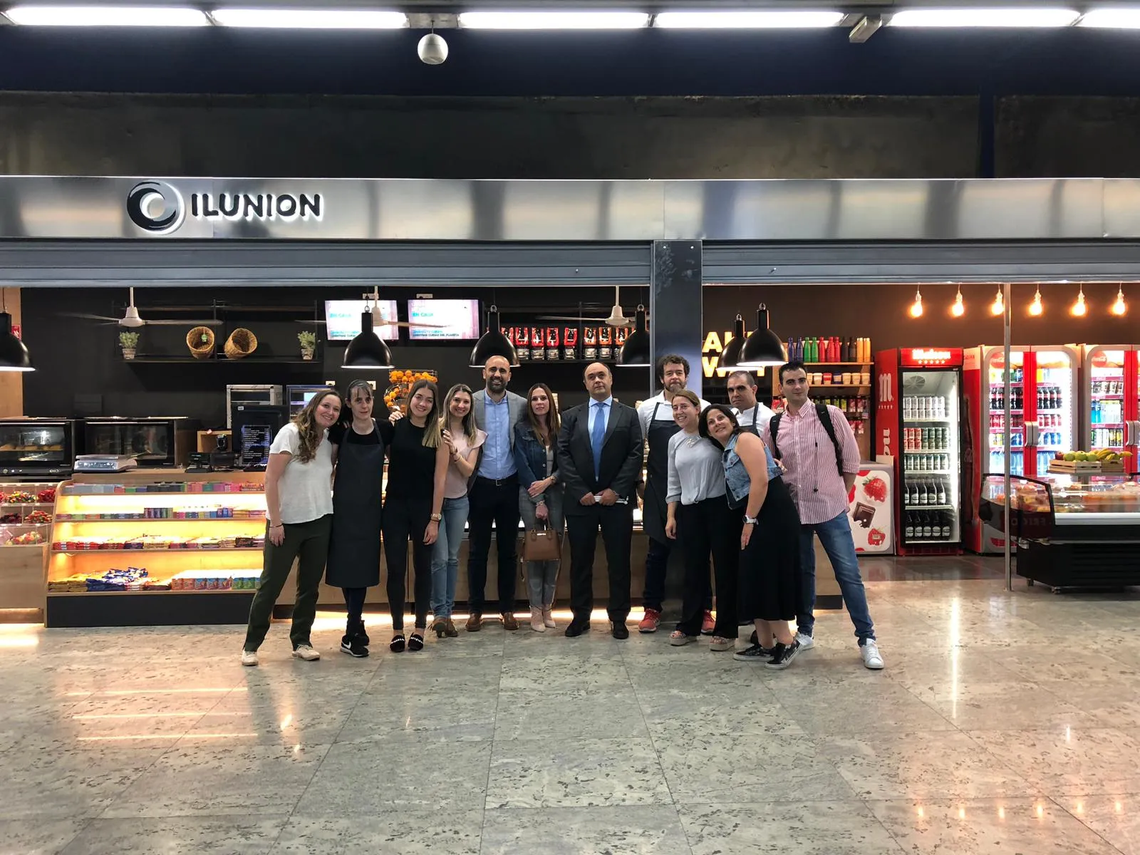 Fotografía de familia delante de la nueva tienda de ILUNION Retail en el intercambiador de la estación de Nuevos Ministerios