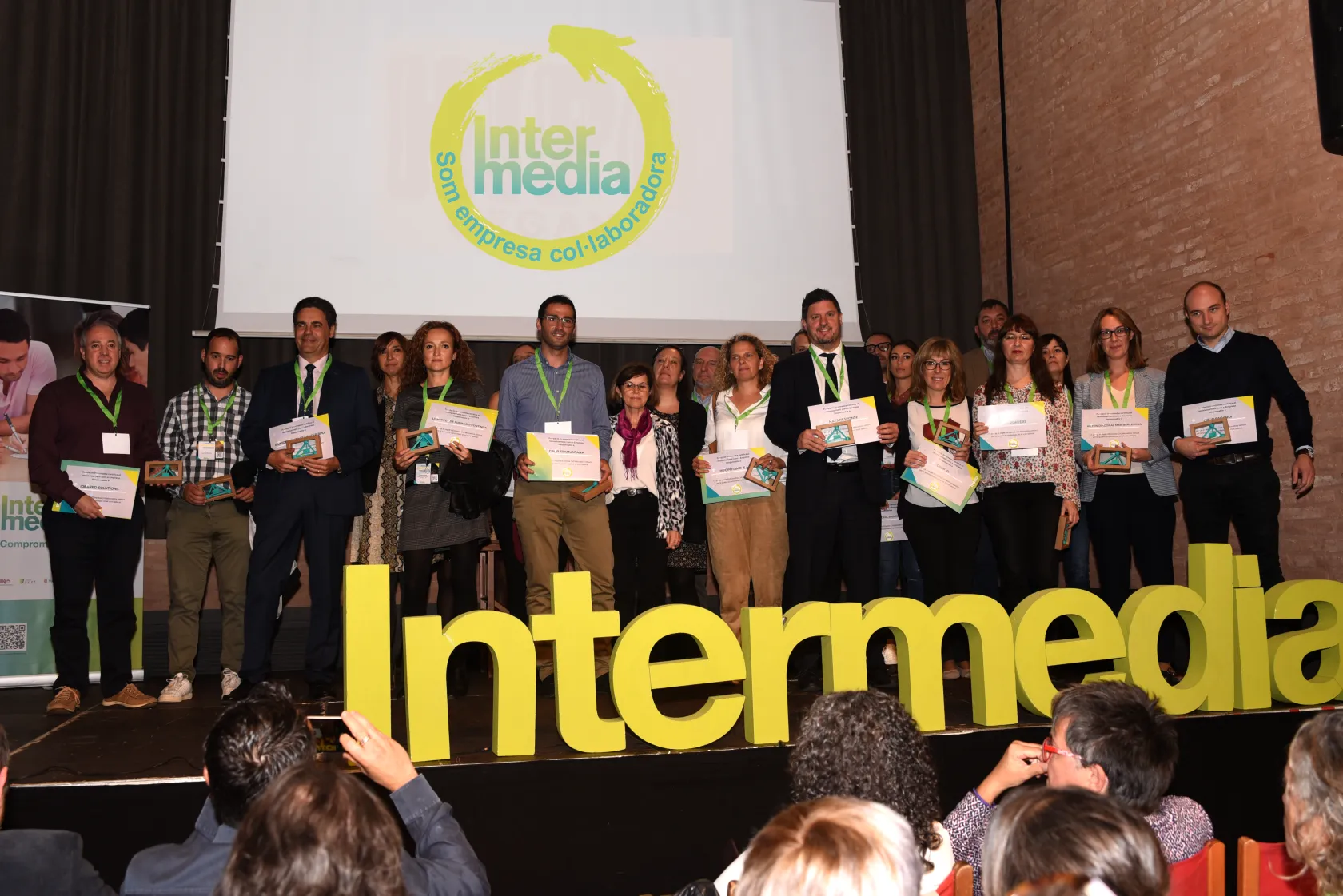 Fotografía de familia durante la recogida del reconocimiento en la jornada #FeinaFutur2019