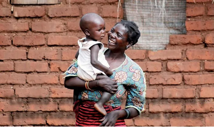 En la fotografía aparece una mujer que sostiene a un niño en brazos