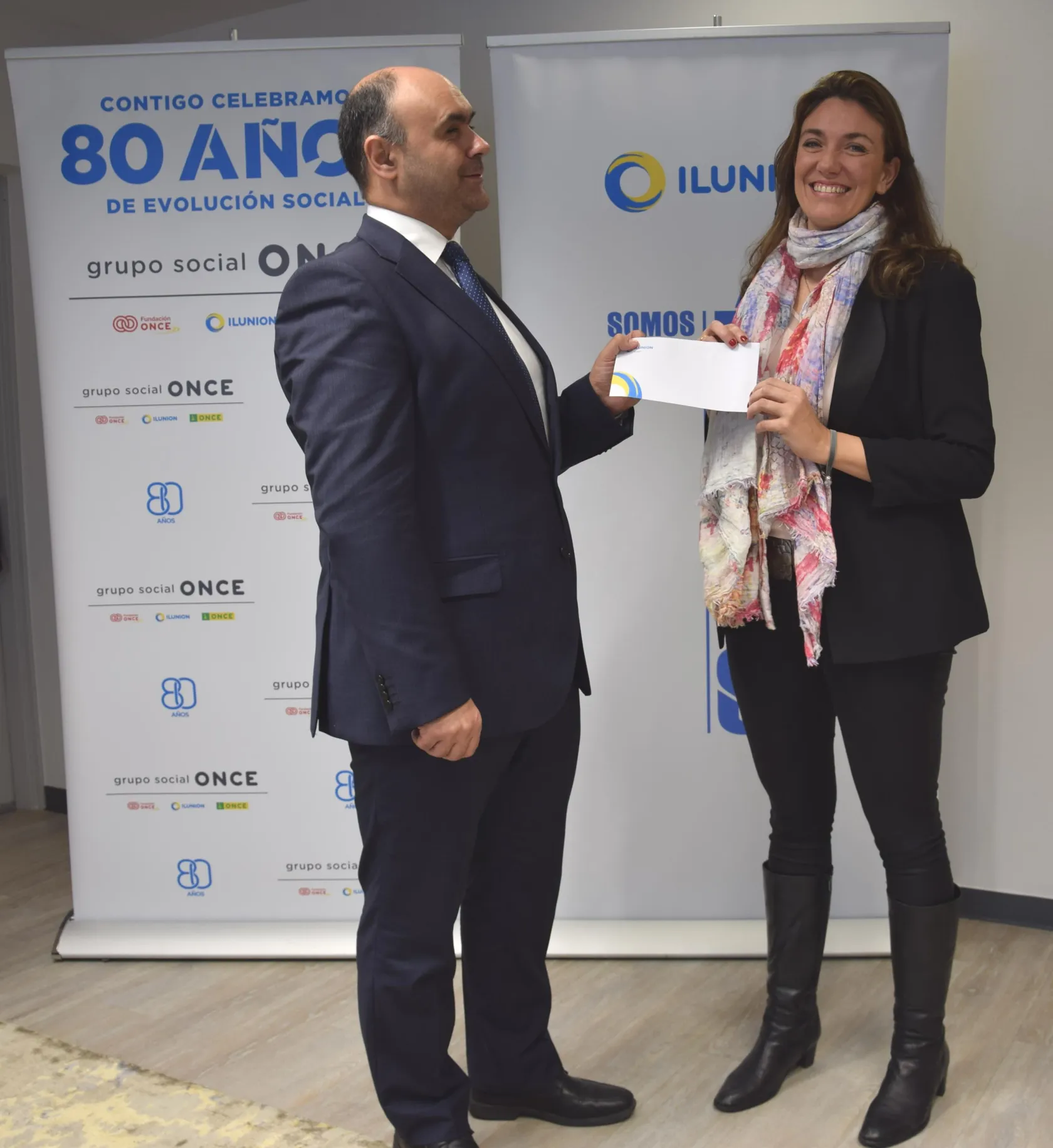 De izquierda a derecha: el consejero delegado de ILUNION Retail, Antonio Barea, entrega el cheque a Elisa Cuadrado, miembro del área de Empresas de la AECC de la Junta Provincial de Madrid 