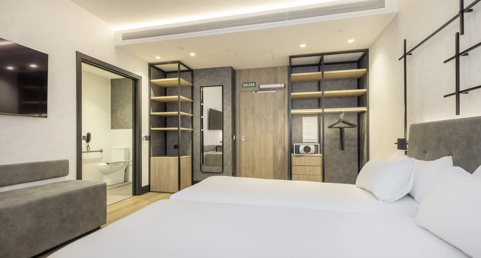 Imagen de una habitación en primer plano con un baño accesible en segundo plano 