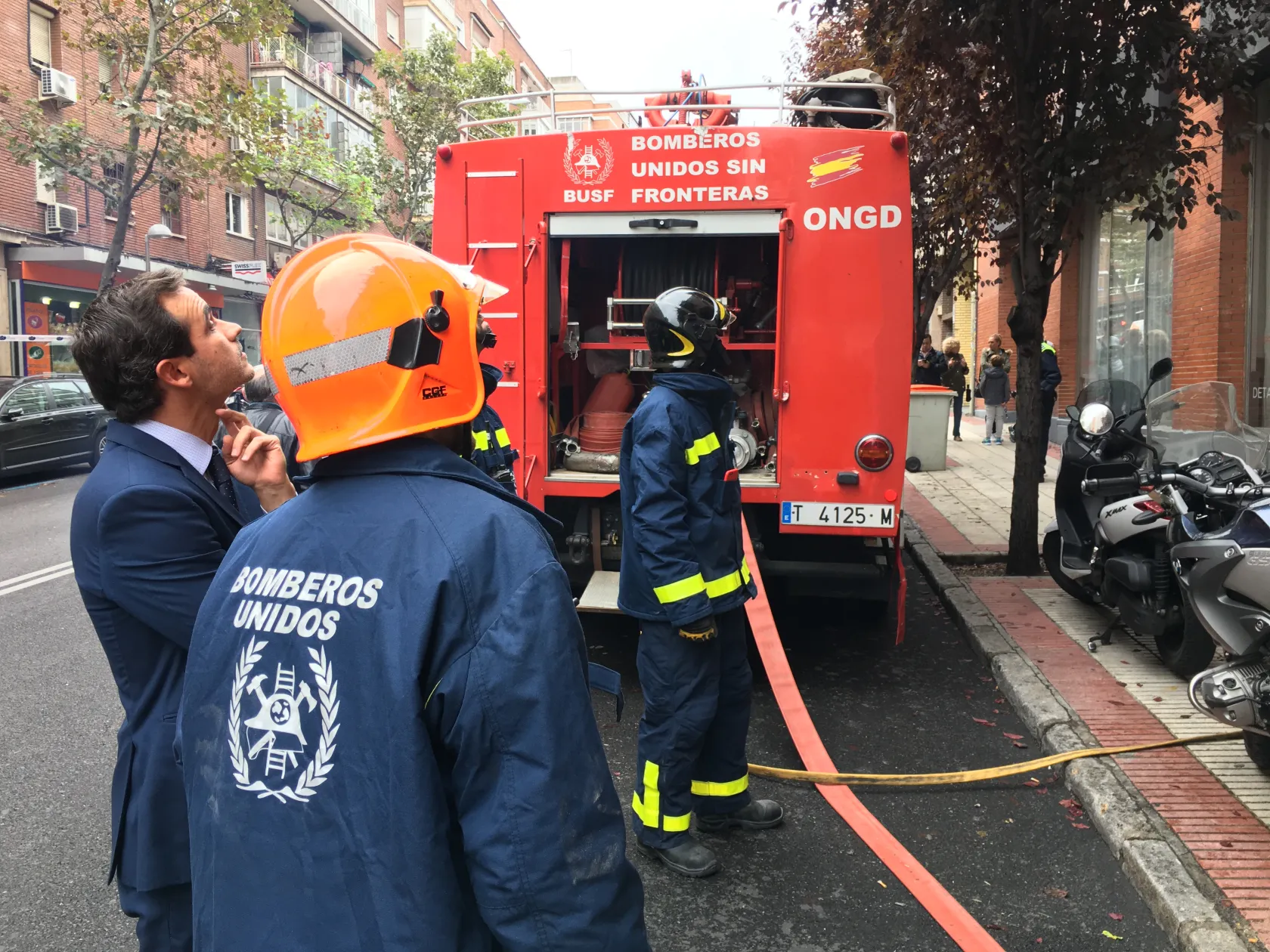 Bomberos sacando de su camión las mangueras de agua 