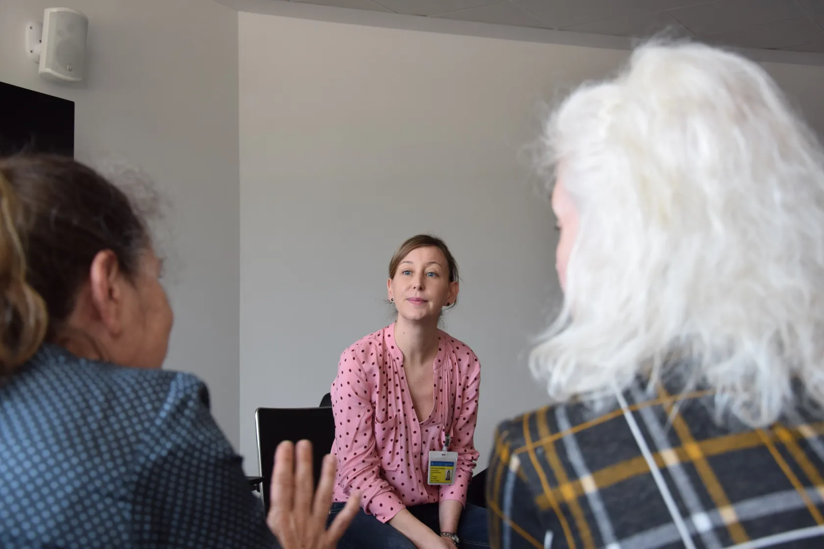 La psicóloga del taller de tarde escucha atentamente a dos de las mujeres