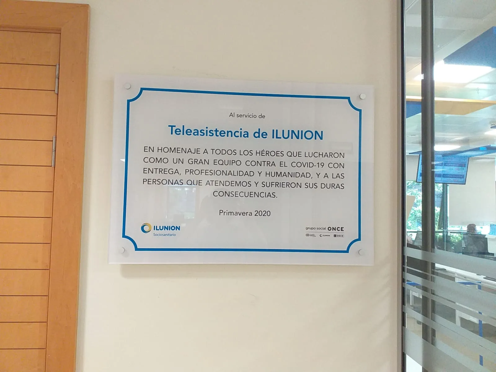 Placa homenaje de ILUNION Sociosanitario colocada en una pared de la central de teleasistencia