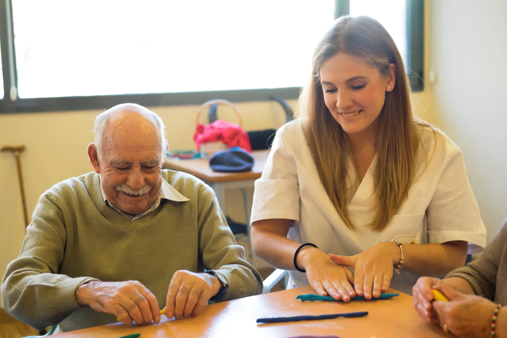Una profesional de ILUNION Sociosanitario junto a una persona usuaria