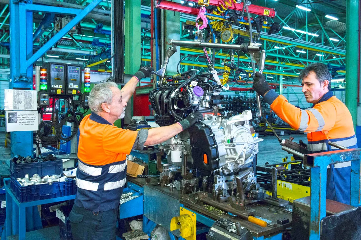 imagen de dos trabajadores de ILUNION manipulando un motor en instalaciones de ILUNION 