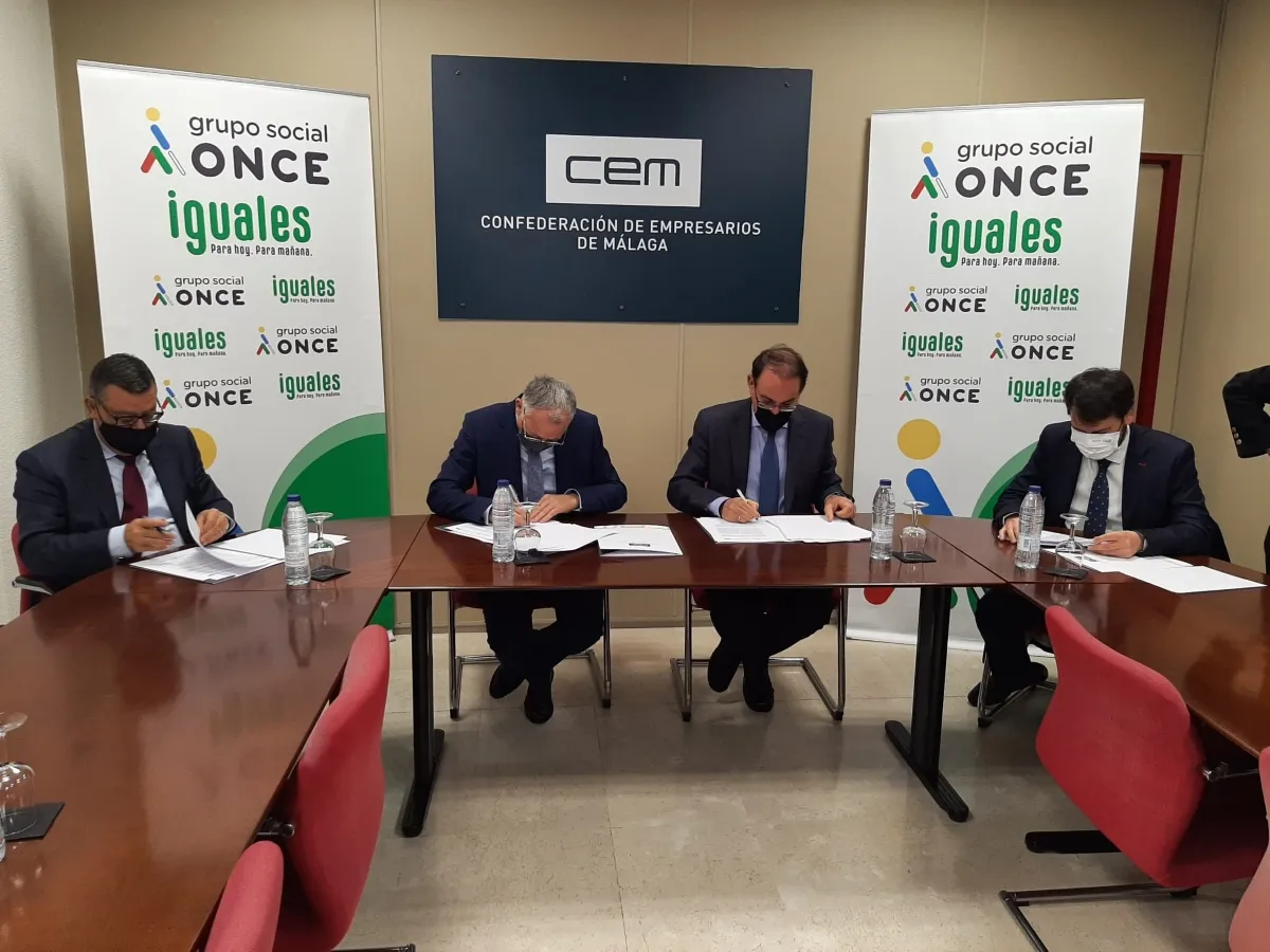 Foto en la que aparecen firmando los representantes de las entidades